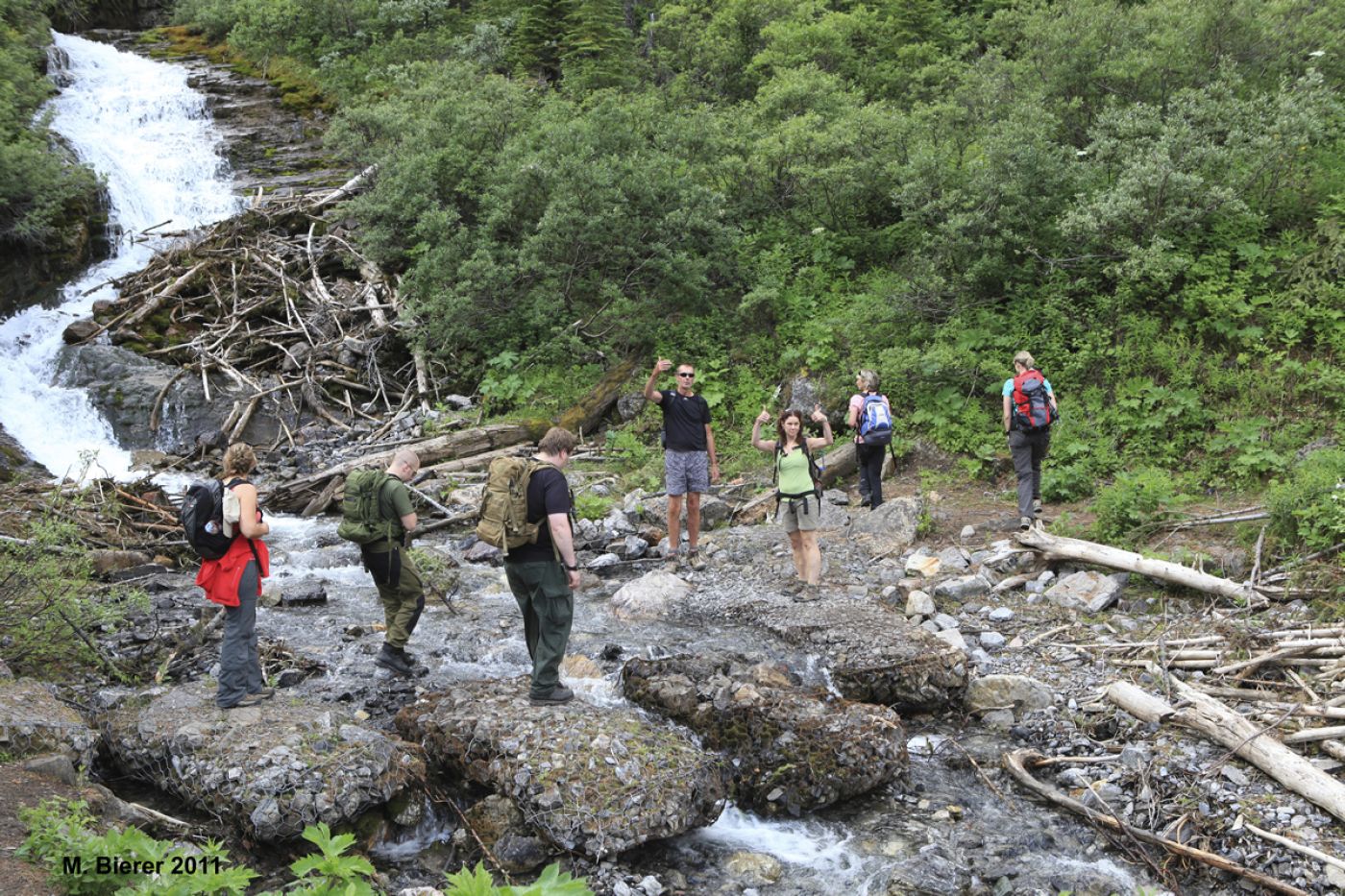 guided group crossing creek in canadian rocky mountains | geführte gruppe bei bachüberquerung in den kanadischen rockies
